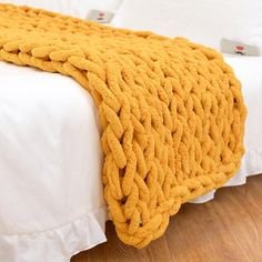 a yellow blanket on top of a white bed