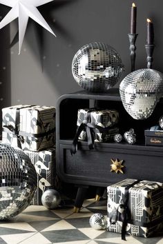 disco balls, candles and other decorations are arranged on a black table with checkered flooring