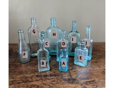 several empty glass bottles sitting on top of a wooden table with letters written in them