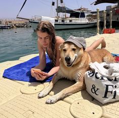 a woman laying on the ground next to a dog