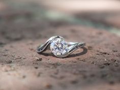 a diamond ring sitting on top of a rock