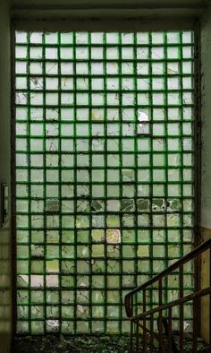 an open window with bars on the glass in front of it and stairs leading up to it