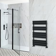 a bathroom with a black towel rack next to a walk in shower and a white tiled wall