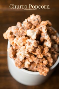 a white bowl filled with popcorn on top of a wooden table and text overlay reads churro popcorn