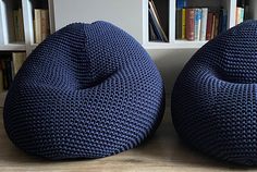 two blue bean bags sitting on top of a wooden table next to bookshelves