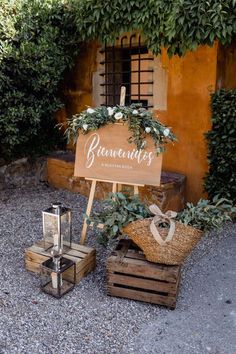 a wooden sign sitting on top of a table next to some crates filled with plants