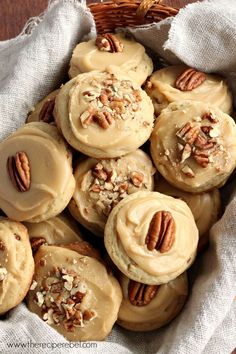 a basket filled with cookies covered in frosting and topped with pecans, nuts