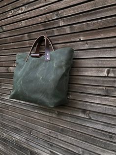 The material I used to make this bag is an American heavy weight waxed canvas. The color is forest green. With leather base in hand waxed leather I made it into an everyday bag, with vegetable tanned leather handles.  There is one zipper pocket inside. The bag closes with a pouch button under the leather strap   Fully lined with a waterproof cotton canvas, this is to avoid staining when spilling liquids inside All the bags are made and designed by myself and handmade with care and attention for Green Canvas Tote Weekender Bag, Waxed Canvas Tote With Reinforced Handles, Green Duck Canvas Bag With Canvas Lining, Green Waxed Finish Tote Shoulder Bag, Green Duck Canvas Tote Bag, Outdoor Canvas Bag With Leather Handles, Waxed Canvas Tote Weekender Bag, Green Waxed Canvas Tote Bag, Green Leather Handled Tote Weekender Bag