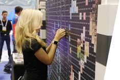 a woman writing on a wall with people in the background