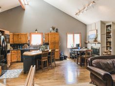 a large open kitchen and living room with wood flooring in an attic style home