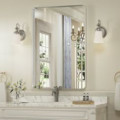 a bathroom with a large mirror above the sink and a fireplace in front of it