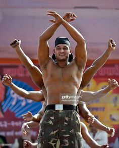 a man standing on top of another man with his hands in the air and other people behind him