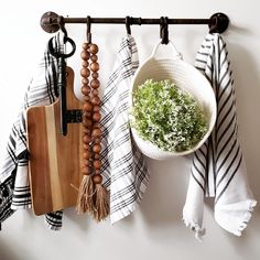 a wooden cutting board sitting next to a potted plant