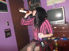 a woman in a pink and black outfit drinking from a bottle