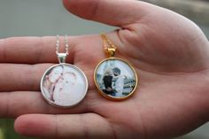 a person holding a small pendant with a photo on it's front and back