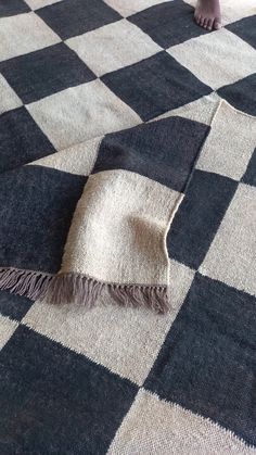 a black and white checkered rug with a person standing on it