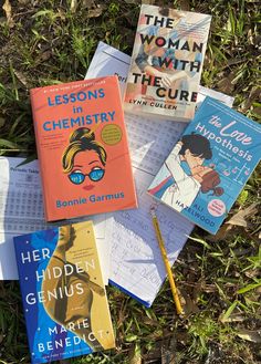 four books are laying on the grass