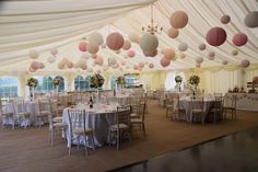 the inside of a tent with tables and chairs set up for a wedding or other function