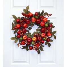 an apple wreath is hanging on the front door with berries, leaves and berries around it