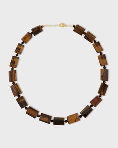 This stunning necklace features a polished tiger's eye stone suspended from a delicate 14k gold chain. The tiger's eye stone is known for its beautiful chatoyancy, which creates a mesmerizing play of light. This necklace is a unique and eye-catching piece that is perfect for everyday wear. Tigers Eye 14 Karat Gold 24 to 26 inches Handmade in NYC Rainbow Sapphires, Tigers Eye Necklace, Citrine Crystal, Tiger Eye Stone, Eye Stone, Aquamarine Blue, Tigers Eye, Tiger's Eye, Stunning Necklace