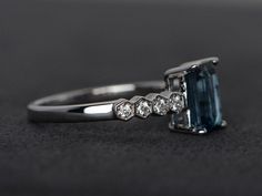 Welcome to my shop, you can find many beautiful gemstone jewelry here, and you also can ask for customized service. Main Stone: London blue topaz, emerald cut, measures 6X8mm, weight 2.00 carats Accent Stones: cz Metal: 925 sterling silver plated with rhodium so. I also can provide metal options such as 14k solid yellow/white/rose gold Setting: four claw basket setting If you want to know more rings please go to my shop home: https://www.etsy.com/shop/XCjewelryStudio?ref=hdr_shop_menu It's a per Emerald Cut Topaz Ring With Sapphire Accent Stones, Modern Emerald Cut Topaz Ring For Wedding, Emerald-cut Sapphire Ring With Topaz Accent Stones, Emerald Cut Topaz Promise Ring With Diamond Accents, Emerald Cut Topaz Ring With Diamond Accents For Promise, Emerald Cut Sapphire Ring For Proposal, Blue Topaz Ring Engagement, Topaz Ring Engagement, Engagement Ring Blue