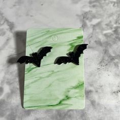 a pair of black bats on a green marble background