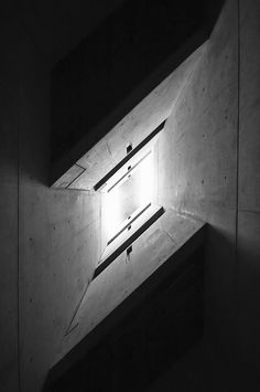 the light shines brightly through the opening in the concrete building's roof window