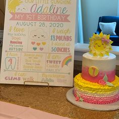 a baby's first birthday cake next to a sign