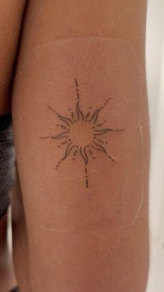 a woman's arm with a tattoo on the back of her leg and an image of a sun