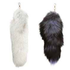 two furry items hanging from hooks on a white background, one is black and the other is grey