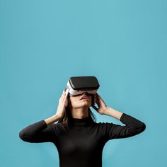 a woman in black shirt holding up a virtual device to her face