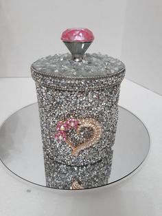 a silver container with a pink heart on it