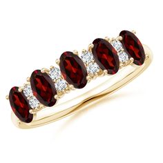 a gold ring with three oval shaped red garnets and two round white diamonds