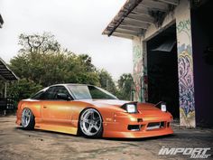 an orange car parked in front of a building