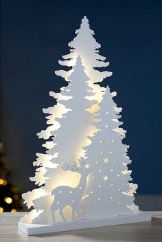 a white christmas tree with lights on it and a deer figurine next to it