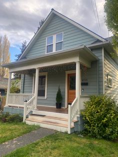 a blue house with white trim on the front porch