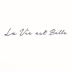 the word la vie est bella written in cursive writing on a white background