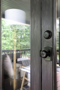 an open door to a patio with chairs and table in the backround area