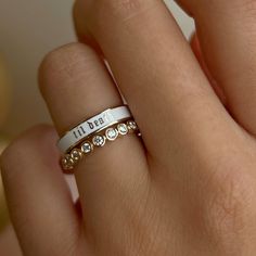 a close up of a person's hand wearing a ring with the word i love you written on it