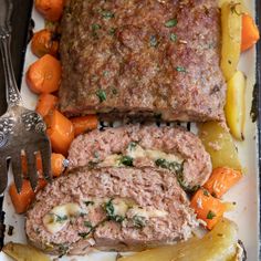 meatloaf, carrots and potatoes on a plate with a fork next to it