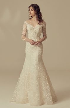 a woman in a wedding dress with long sleeves and an off the shoulder lace top