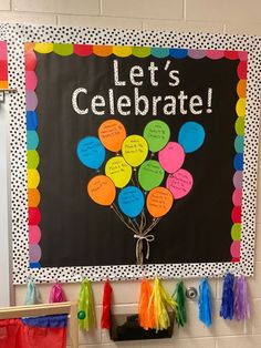 a bulletin board that says let's celebrate with balloons and tassels on it