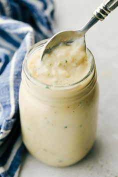 a spoon in a jar filled with food on top of a blue and white towel