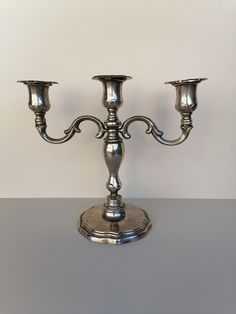 two silver candlesticks sitting on top of a table