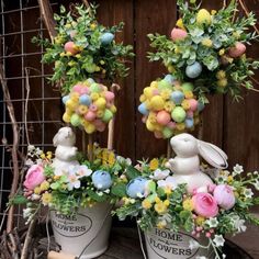 two white buckets filled with flowers and bunnies