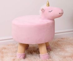 a pink unicorn shaped stool with a gold horn on it's head and legs