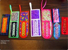 some colorful bags are lined up on a table with string attached to them and one is empty