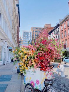 a bicycle parked on the side of a street with flowers in it's basket