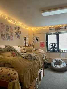 a bed room with a neatly made bed and lights on the wall above it's headboard