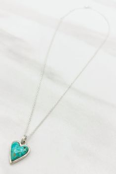 Treat yourself to a little extra sparkle with this beautiful Turquoise and Silver Heart Necklace. Featuring a striking turquoise heart shaped pendant with a glittering silver trim, this look is sure to become your go-to for everyday glam. Love it 'til your heart's content!Details: Handmade Turquoise Heart Pendant Sterling Silver Chain Approximate Dimensions: Length: 17.5" Heart Pendant: 0.5" x 0.5" Turquoise Sterling Silver Charm Necklace, Turquoise Heart Necklace With Heart Beads, Elegant Turquoise Necklace With Heart Charm, Dainty Blue Turquoise Pendant Necklace, Turquoise Heart Pendant Necklace, Elegant Turquoise Pendant Charm Necklace, Elegant Turquoise Heart Necklace For Gift, Turquoise Heart Charm Jewelry, Turquoise Necklace With Heart Beads As Gift